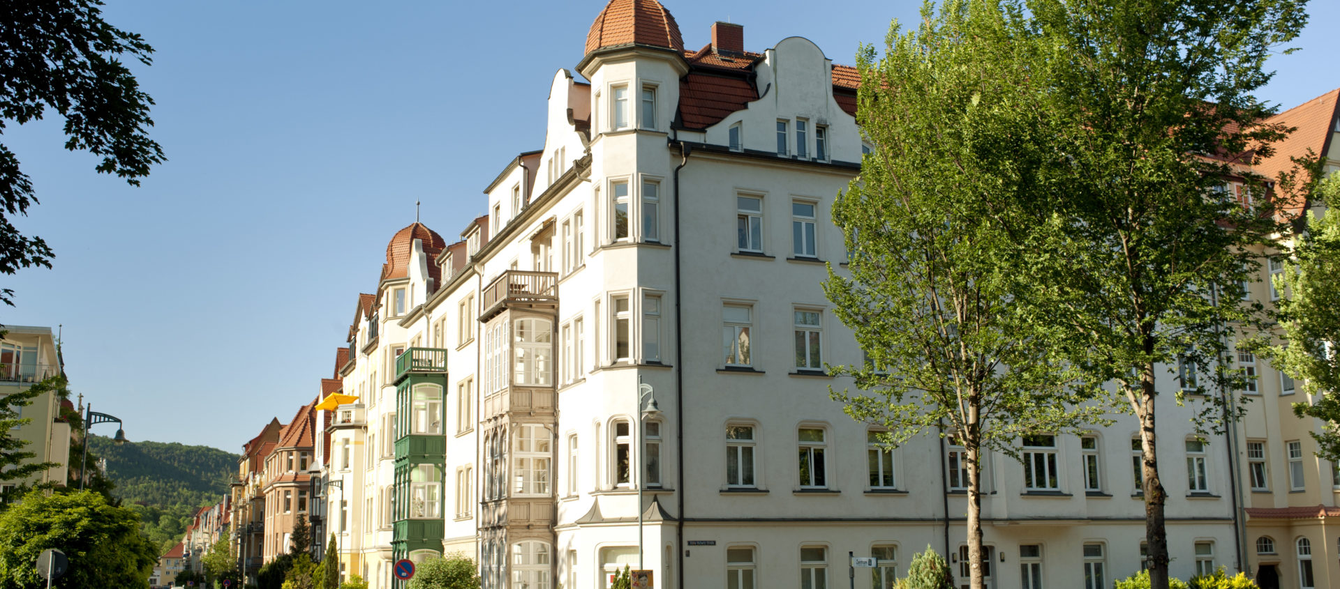 Straßenecke im Damenviertel Jena mit mehrstöckigen Gründerzeit- und Jugendstilfassaden, Bäumen am Straßenrand und parkenden Autos