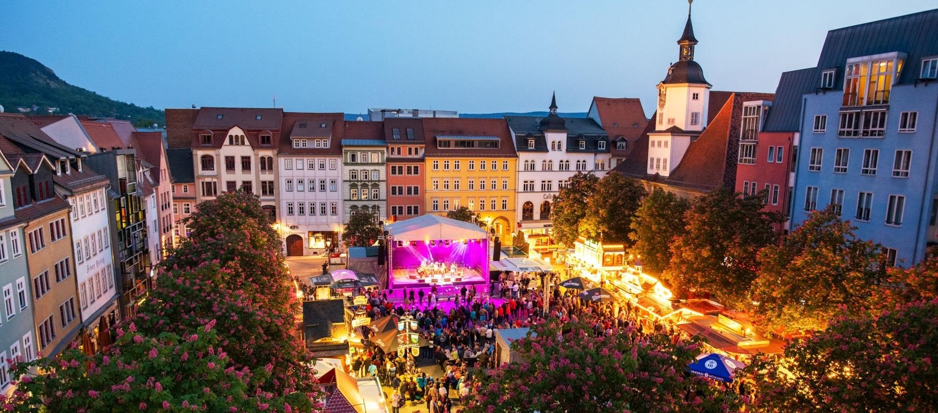 Abendlicher Frühlingsmarkt in Jena mit beleuchtetem Bühnenprogramm und Menschen zwischen historischen Gebäuden