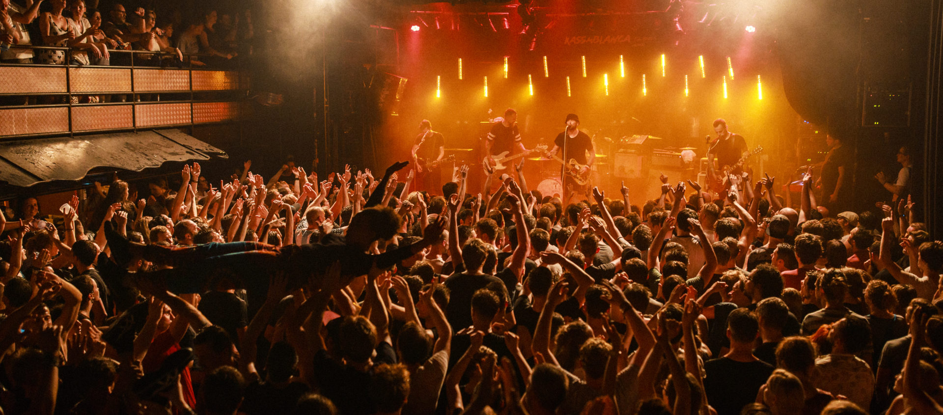 Bühnenaufnahme der Beatsteaks bei einem Konzert im Kassablanca Jena mit einer Menge, die Hände hebt und eine Person beim Crowdsurfen