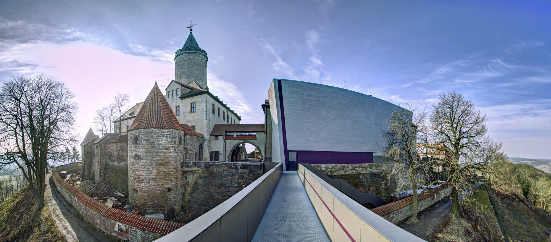 Blick auf die Leuchtenburg mit mittelalterlichen Mauern und Türmen sowie dem modernen Skywalk, der sich als langer, schmaler Steg vom Burgtor aus erstreckt