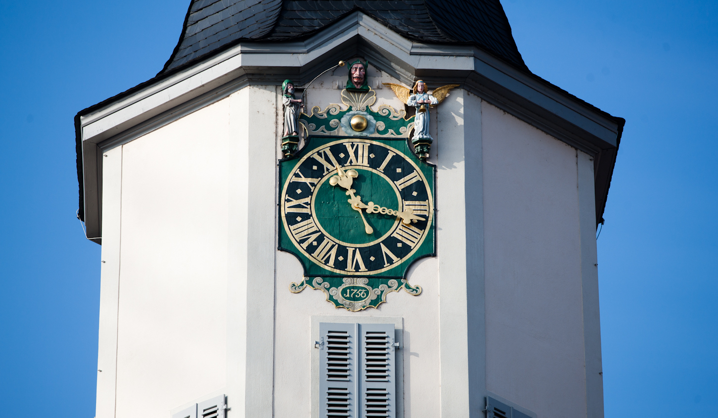 Historische Uhr mit römischen Zahlen und Figuren über dem Zifferblatt am Rathaus in Jena, Baujahr 1756