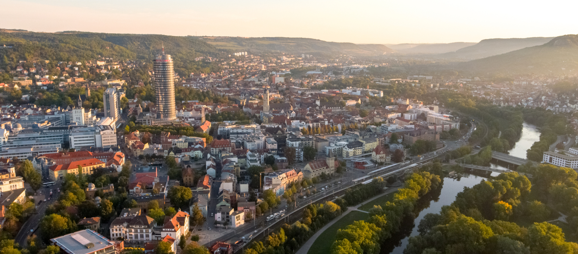 Die Stadt Jena mit der Saale und verschiedenen Gebäuden im Hintergrund
