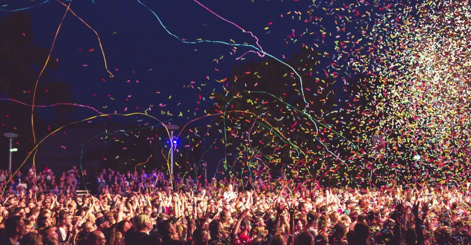 Große Menschenmenge bei der Kulturarena in Jena, umgeben von buntem Konfetti und Luftschlangen in der Nacht