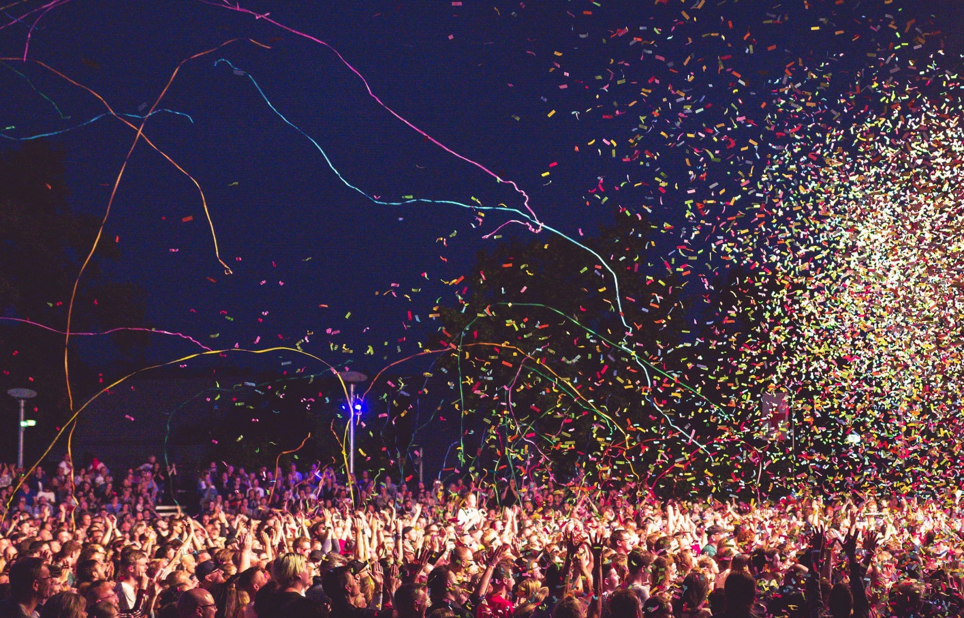 Große Menschenmenge bei der Kulturarena in Jena, umgeben von buntem Konfetti und Luftschlangen in der Nacht